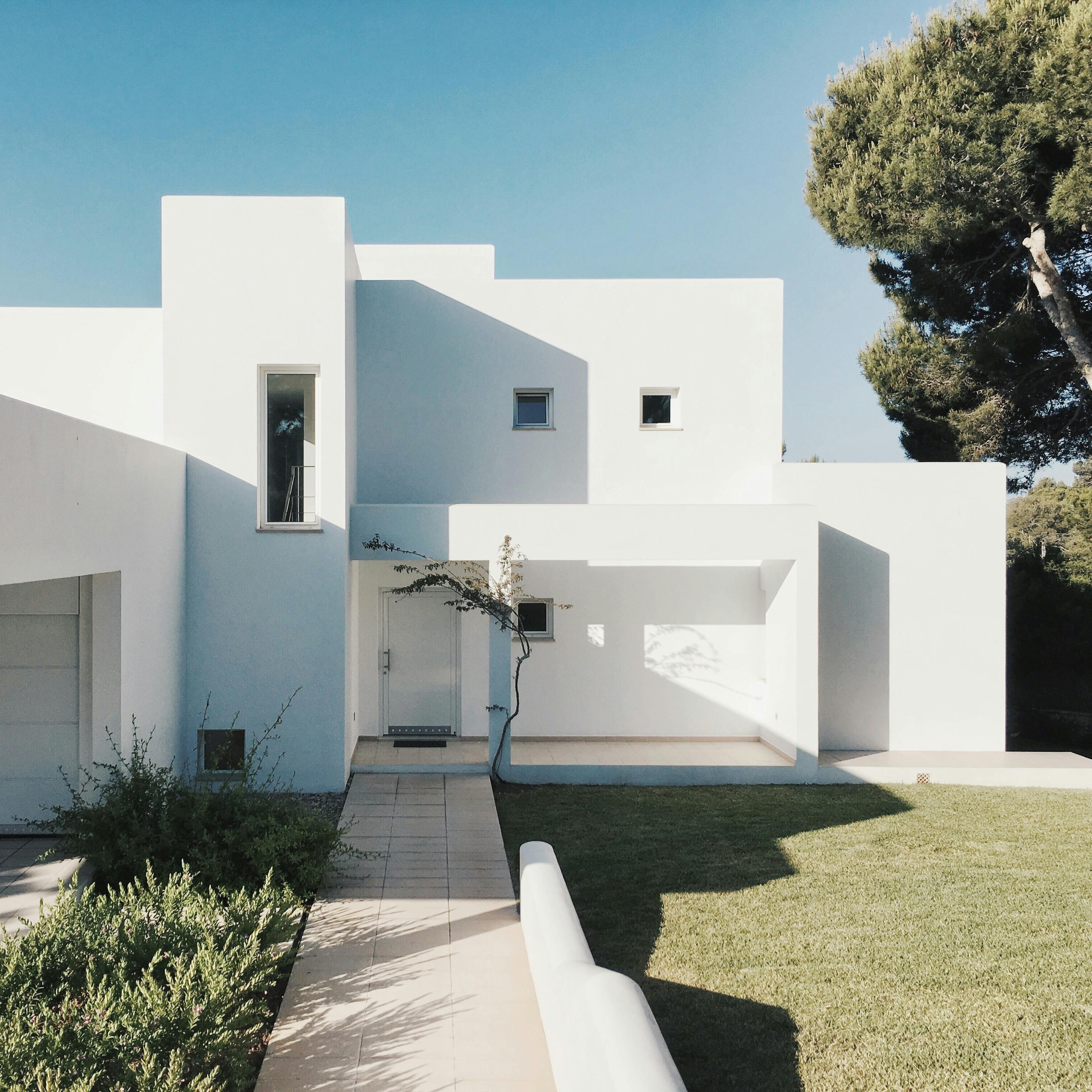 Residencia minimalista con fachada blanca y diseño integrado al entorno